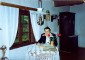 Aivars Jerumanis sēž pie galda Braku viesistabā un raksta Viesu grāmatā.  1992. augustā.
