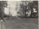 Braki. Skats uz pagalmu no pirts (Dienvidu) puses. Aiz kokiem redzama dzīvojamās mājas un namiņa daļa, cilvēki un autobuss.  1960.gadi.