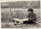 Dzejniece Mirdza Ķempe sēž pie  dīķa laipas  Brakos un raksta. 1958.g. 12. oktobrī.